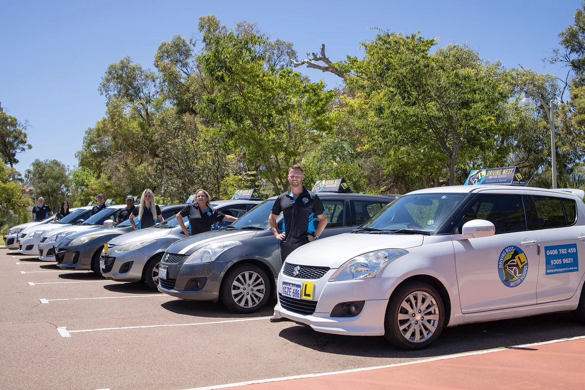 Driving West Driving West driving instructors standing beside their branded learner cars